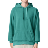 A person wearing a solid teal green pullover hoodie with matching drawstrings and a front kangaroo pocket