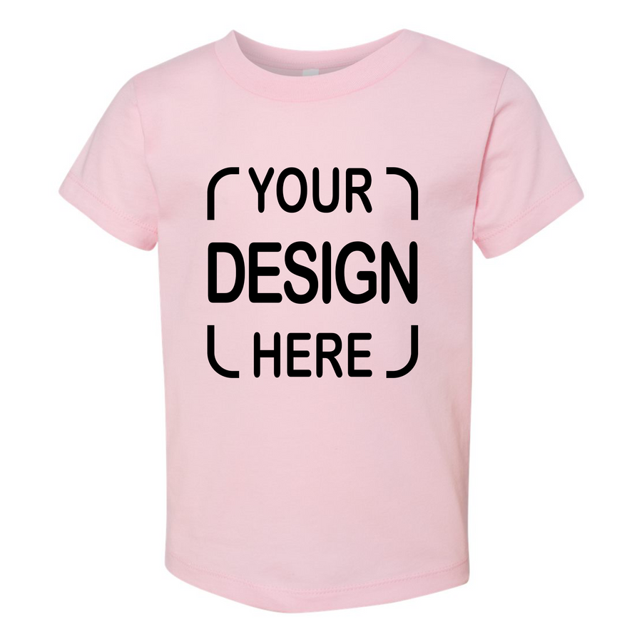 A light pink short-sleeve t-shirt with black placeholder text reading 'YOUR DESIGN HERE' printed on the front.