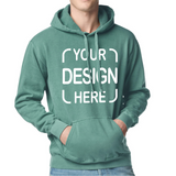 A person wearing a sage green pullover hoodie with a white customizable text graphic reading 'YOUR DESIGN HERE' on the front