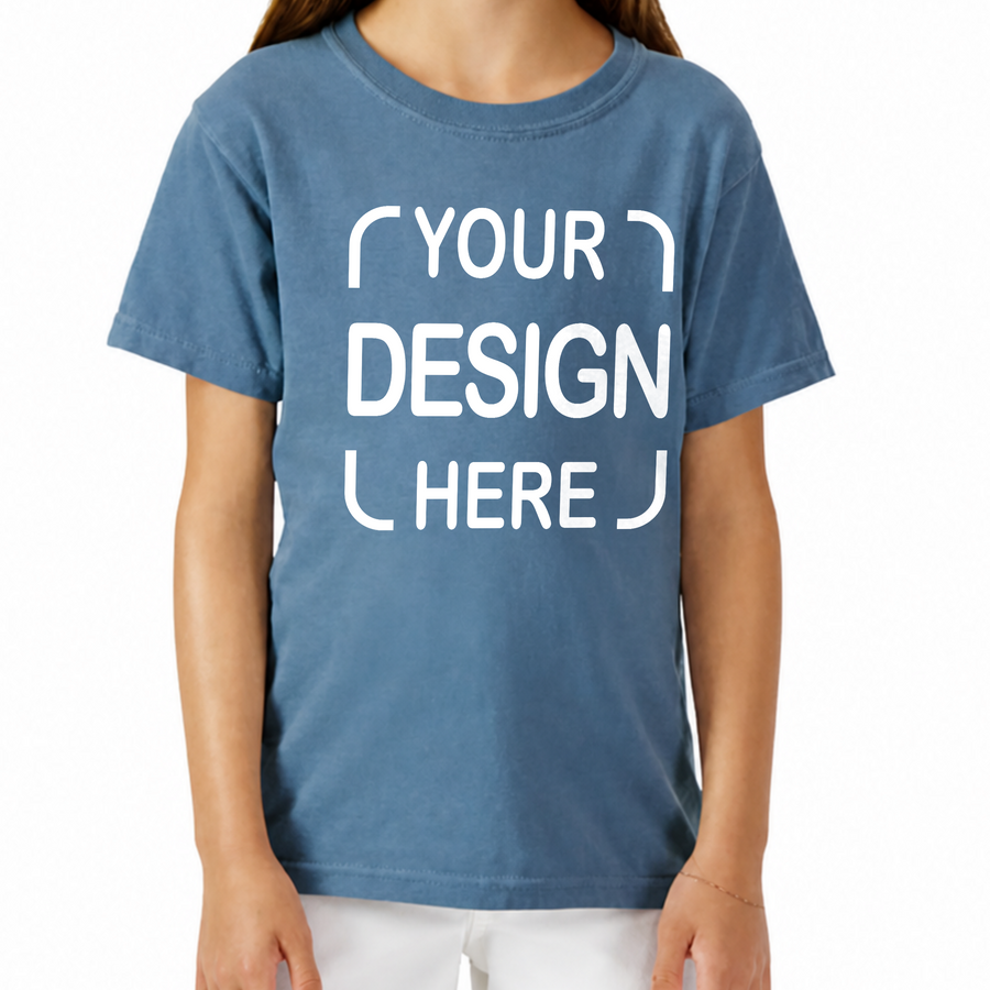 A person wearing a faded medium blue short-sleeve T-shirt with large white placeholder text reading 'YOUR DESIGN HERE' on the front.