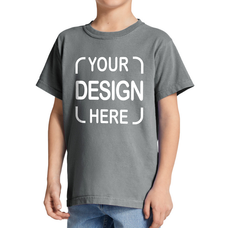 A child wearing a dark gray custom graphic t-shirt with white placeholder text reading 'YOUR DESIGN HERE',