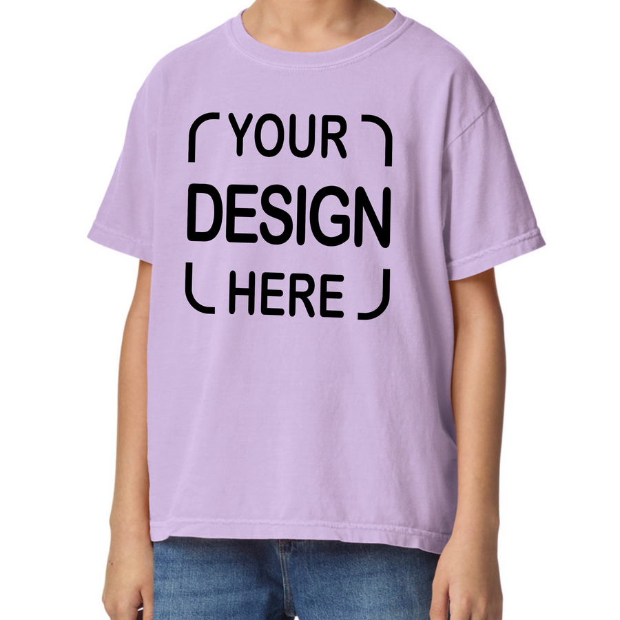 A child wearing a light lavender-purple t-shirt with black placeholder text reading 'YOUR DESIGN HERE' printed on the chest